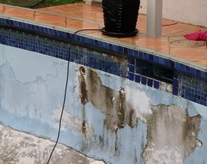 Effects of poor drainage around pool and causing in part delamination of render.